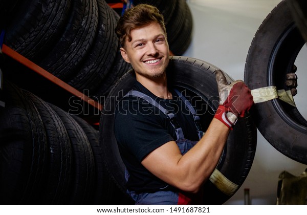 Mechanic choosing tires in\
a warehouse