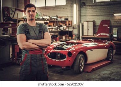Mechanic In Classic Car Restoration Workshop