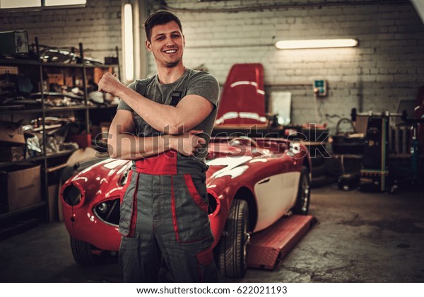 Mechanic in classic\
car restoration\
workshop