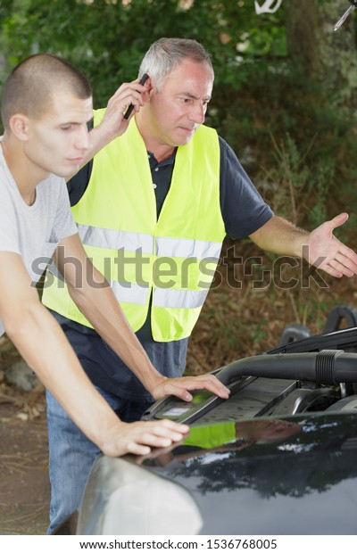 mechanic and\
customer discussing problem with\
car