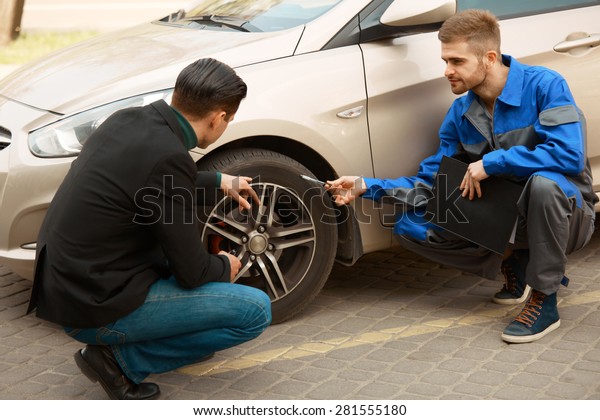 Mechanic and Customer Discussing Problem With Car.
Auto Repair Shop