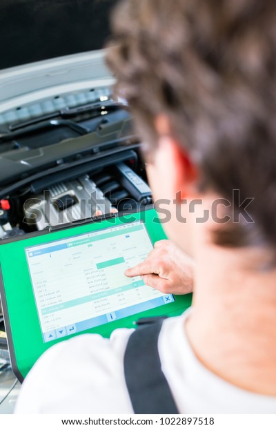 Mechanic
with diagnostic tool in car service
workshop