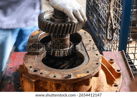 Mechanic disassembling Differential gear hub part during repair gear axle assembly. 