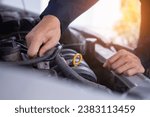 mechanic is doing the annual car inspection. Car repair shop is ready to serve. Car mechanic inspects car engine problems technical inspection engine safety Maintenance Changing the engine oil