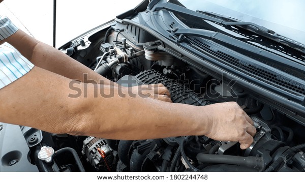 A mechanic\
examining the damaged engine