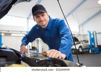 Mechanic examining under hood of car at the repair garage - Powered by Shutterstock