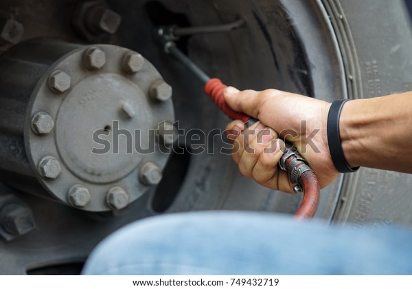 Mechanic is filling truck\
tire