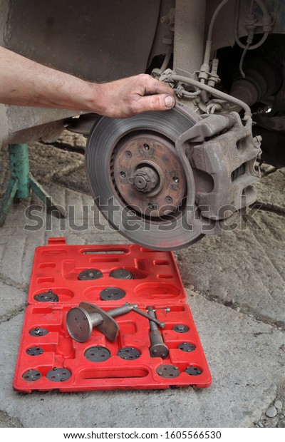 Mechanic fix car disc brakes using disc brake caliper\
tool set