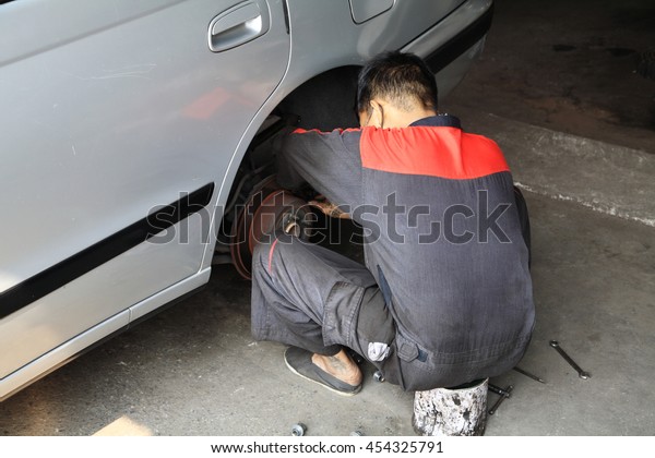 Mechanic fix disk\
break and wheel on old\
car