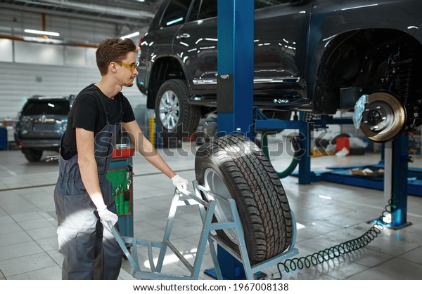 Mechanic fixes\
problem with wheel, car\
service
