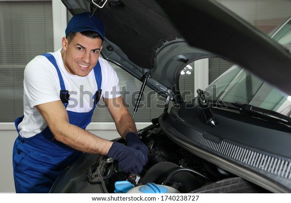 Mechanic fixing car\
at automobile repair\
shop