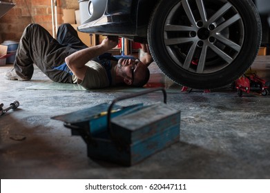 Mechanic Fixing A Car At Home	