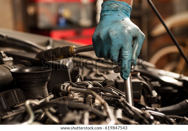 mechanic fixing a car at\
home
