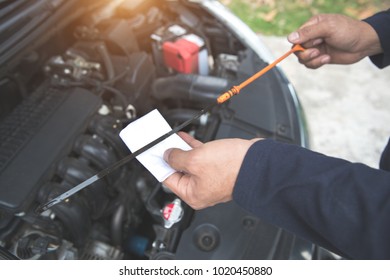 Mechanic Hand Checking Oil Level
