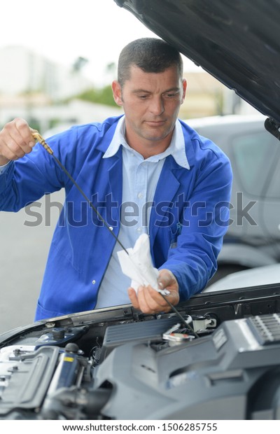 mechanic hand checking oil\
level