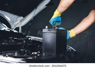 The Mechanic Hand Is Pulling Up An Car Old Battery For Replacement