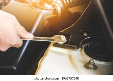 Mechanic hand is unscrewing the metal nut with a combination wrench spanner - Shutterstock ID 1968757648