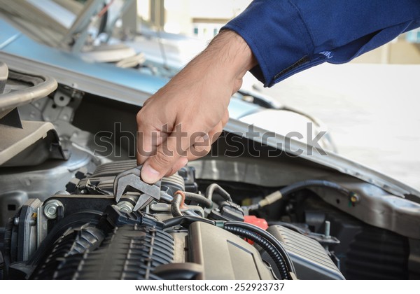 Mechanic hand with\
wrench fixing car\
engine