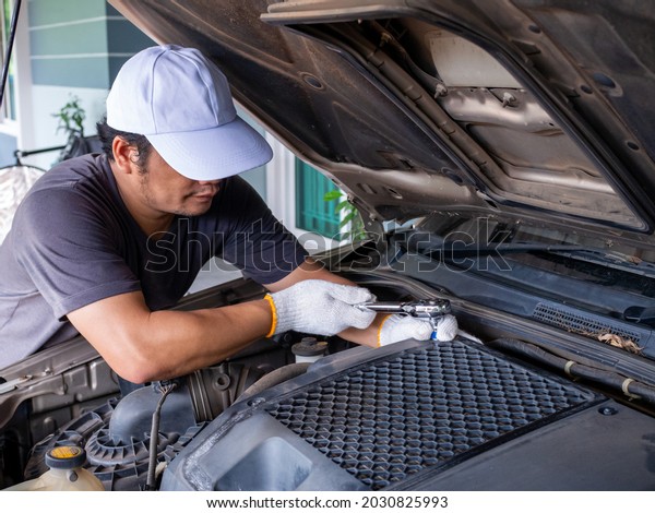 Mechanic holding a block wrench handle while fixing
a car.