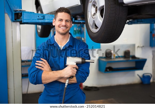 Mechanic\
holding a drill tool at the repair\
garage