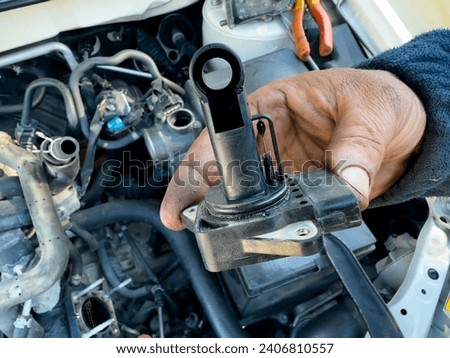 Mechanic holding Intake manifold absolute pressure sensor (MAP sensor ) in hand for examining and cleaning the map sensor