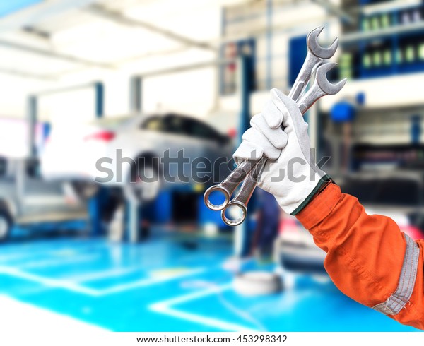 Mechanic
holding pair of wrenches at the repair
garage