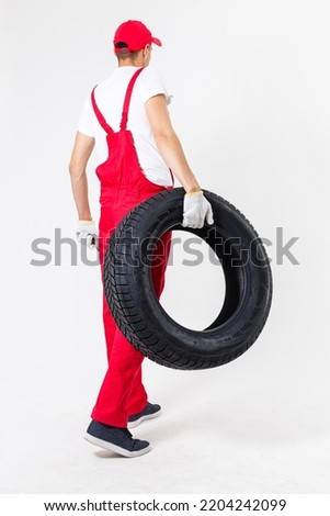 Mechanic holding a tire tire at the repair garage. replacement of winter and summer tires.