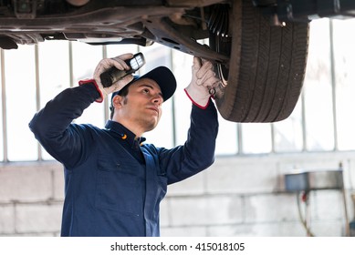 Mechanic inspecting a lifted car - Powered by Shutterstock