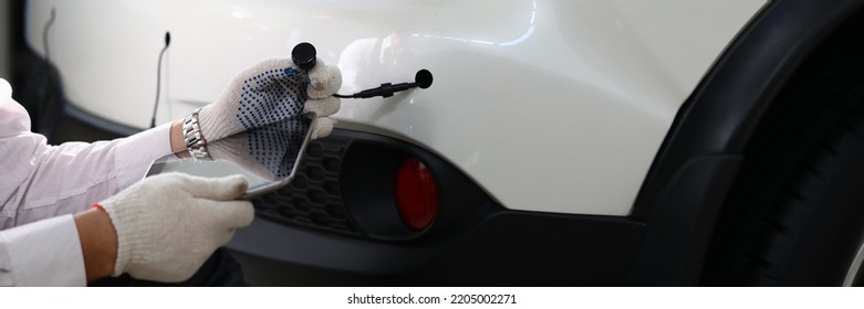 Mechanic installs parking sensors on car closeup - Shutterstock ID 2205002271