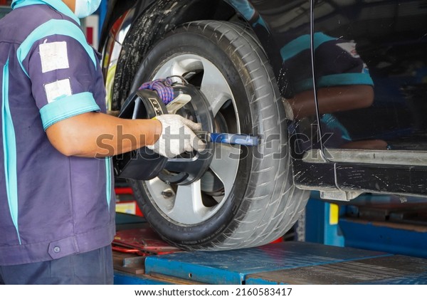 mechanic installs the sensor\
during suspension adjustment,wheel alignment work at a repair\
station.
