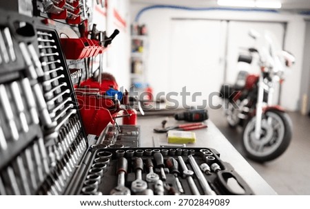 Mechanic Instruments And Tools On A Workbench With A Motorcycle In A Garage