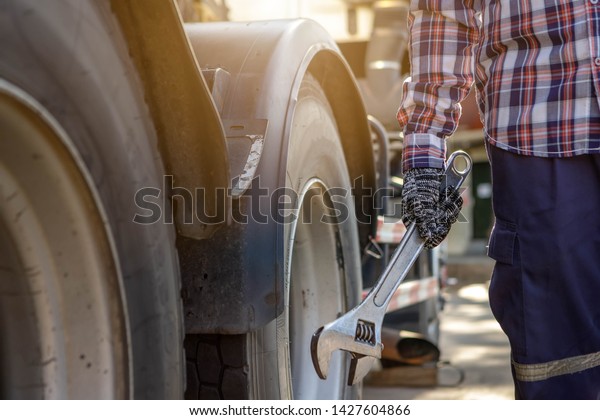 Mechanic with Large Wrench in\
Hand Taking Look at on the Truck,Concept truck maintenance,spot\
focus.