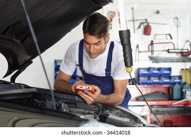 Mechanic Leaning On Bonnet With Tester Equipment