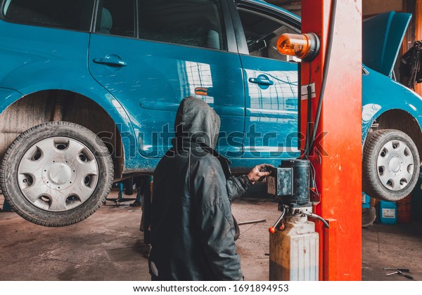 The mechanic lifted the car with a lift to service\
the engine