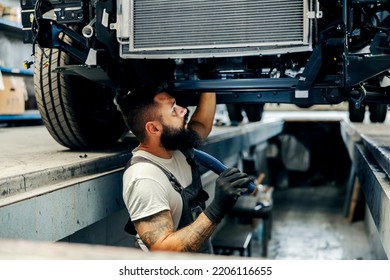 A mechanic looking at malfunction on a vehicle. - Shutterstock ID 2206116655