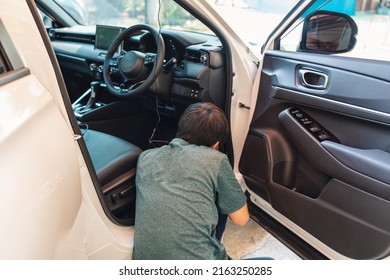 Mechanic man checking and installing dash cam device with wire inside a car at workshop garage - Shutterstock ID 2163250285