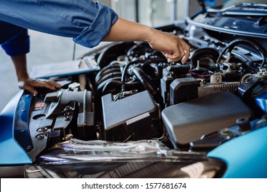 Mechanic man examining and maintenance to customer the engine a vehicle car hood, Safety inspection test engine before customer drive on a long journey, transportation repair service center - Shutterstock ID 1577681674