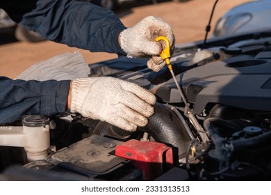 A mechanic man' hannds checking engine oil level