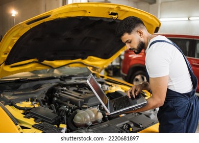 Mechanic man mechanic manager worker using a laptop computer checking car in workshop at auto car repair service center. Engineer young man looking at inspection vehicle details under car hood - Powered by Shutterstock