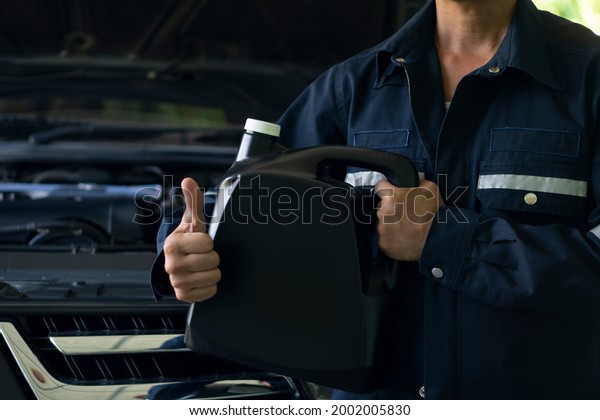 Mechanic man ready to wear\
Mechanic\'s set. Holding a\
gallon of engine oil black color. Thumbs up showing great signs.\
ensure confidence. With\
