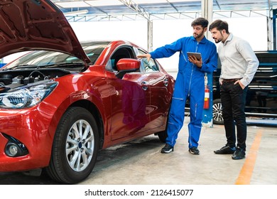 Mechanic man shows the car report on a digital tablet to the Middle East customer at the garage, A mechanic and a customer discussing repairs problems to his vehicle.