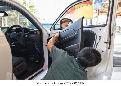 Mechanic man unpacking and assemble vehicle door part for checking car problem or installing speaker in garage workshop - Powered by Shutterstock