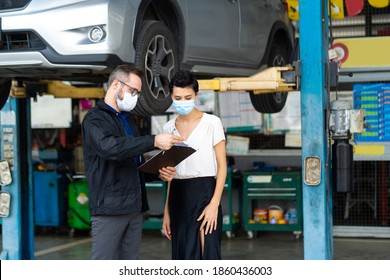 Mechanic Man And Woman Customer Wearing Medical Face Mask Protection Coronavirus And Check The Car Condition Before Delivery. 