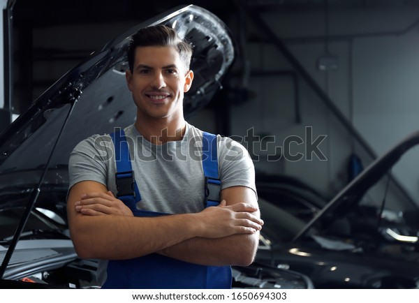 Mechanic near automobile in service center.\
Modern car diagnostic