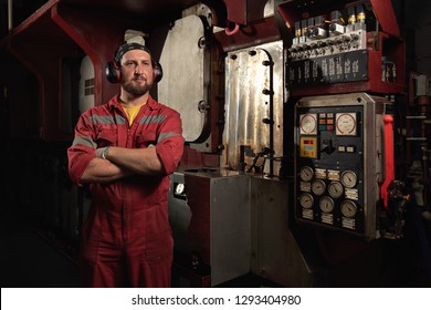 Mechanic Near Ships Main Engine On Dark Background. Industrial Marine Engine. Ship Engine Room. Ship Maintenance. Boat Engine.