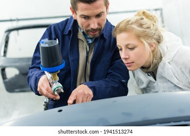 Mechanic With Paint Sprayer Training Female Apprentice