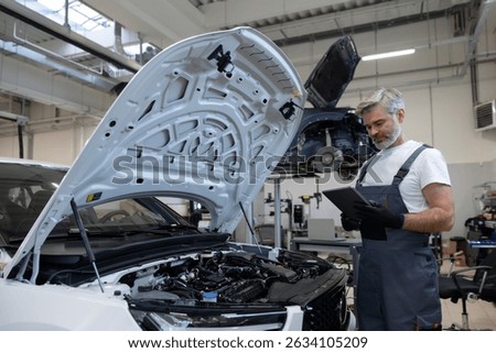 Mechanic performing diagnostics with tablet