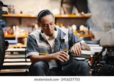 Mechanic pouring himself cup of coffee from thermos when having lunch break - Powered by Shutterstock