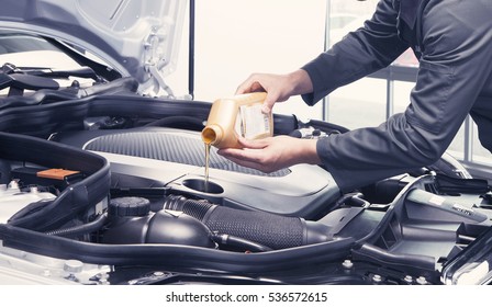 Mechanic pouring oil into car at the repair garage - Powered by Shutterstock