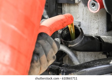 Mechanic Pouring Oil Into The Engine Of The Truck